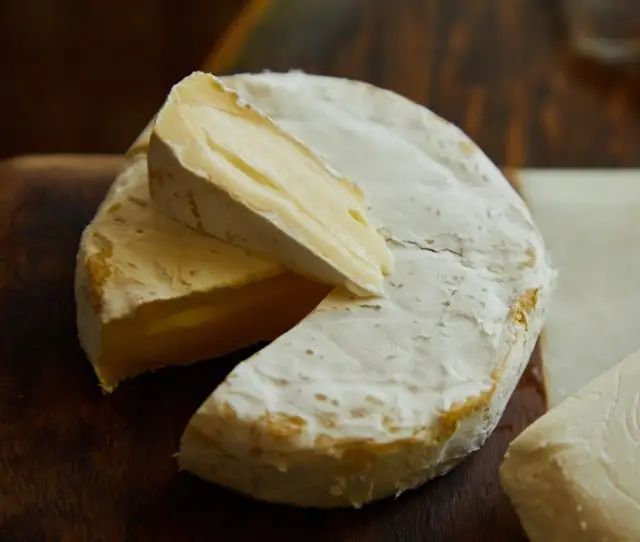 Handwerklich hergestellter Käse und Brot auf einem Holzbrett